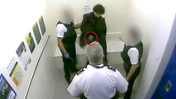 Louis De Zoysa (centre, top) who is holding an item (circled in red) in his hand, seco<em></em>nds before Sergeant Matt Ratana (centre) was fatally shot inside a custody block at Croydon custody centre